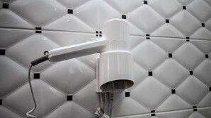 A hairdryer mounted on a wall with a geometric pattern. - Hotel Artur 2 (Sarandë)