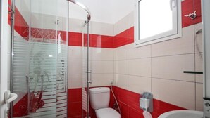A bathroom with a glass shower enclosure, a toilet, and a sink. - Hotel Artur 2 (Sarandë)