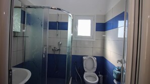 A bathroom with a glass shower enclosure, a toilet, and a sink. - Hotel Artur 2 (Sarandë)