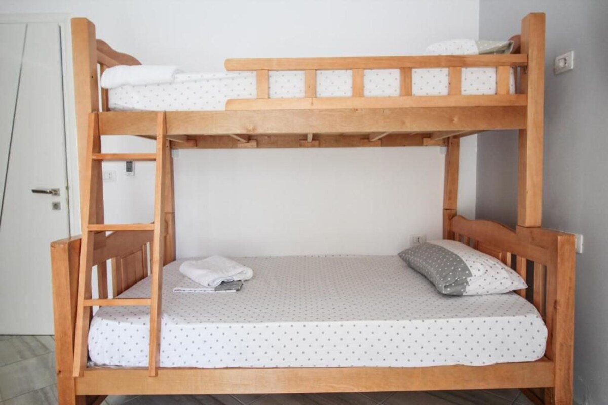 A bunk bed with a white mattress and polka dot bedding.