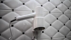 A hairdryer mounted on a wall with a geometric pattern. - Hotel Artur 2 (Sarandë)