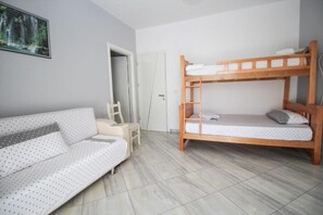 Una habitación con literas, un sofá y una silla.