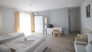 A hotel room with two beds, a desk, a chair, a TV, and a wardrobe. - Hotel Artur 2 (Sarandë)