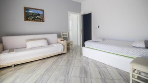 A room with a sofa and a bed, a door, and a framed picture on the wall. - Hotel Artur 2 (Sarandë)