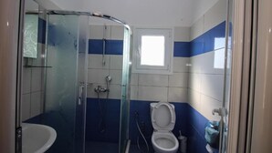 A bathroom with a glass shower enclosure, a toilet, and a sink. - Hotel Artur 2 (Sarandë)