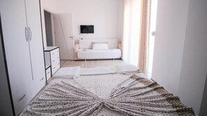 A bedroom with a bed, a TV on the wall, and a wardrobe. - Hotel Artur 2 (Sarandë)