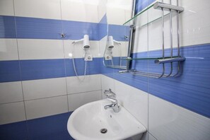 A bathroom with a sink, two wall-mounted hair dryers, and a glass shower enclosure. - Hotel Artur 2 (Sarandë)