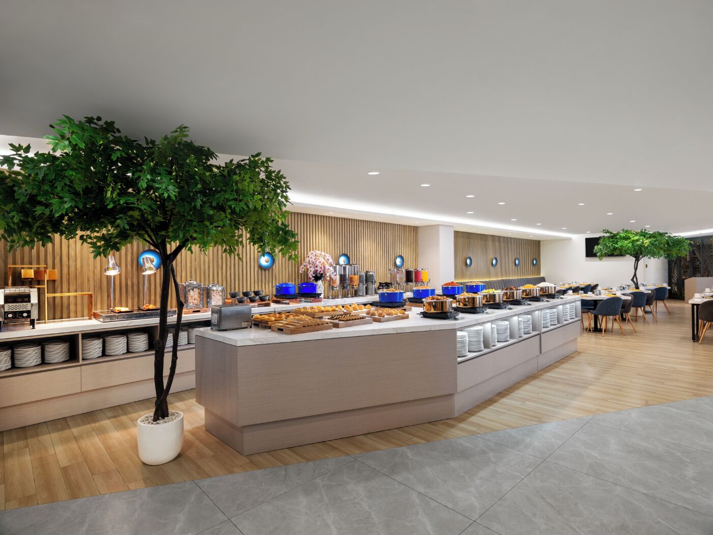 A modern breakfast area with a central counter, seating, and decorative plants.