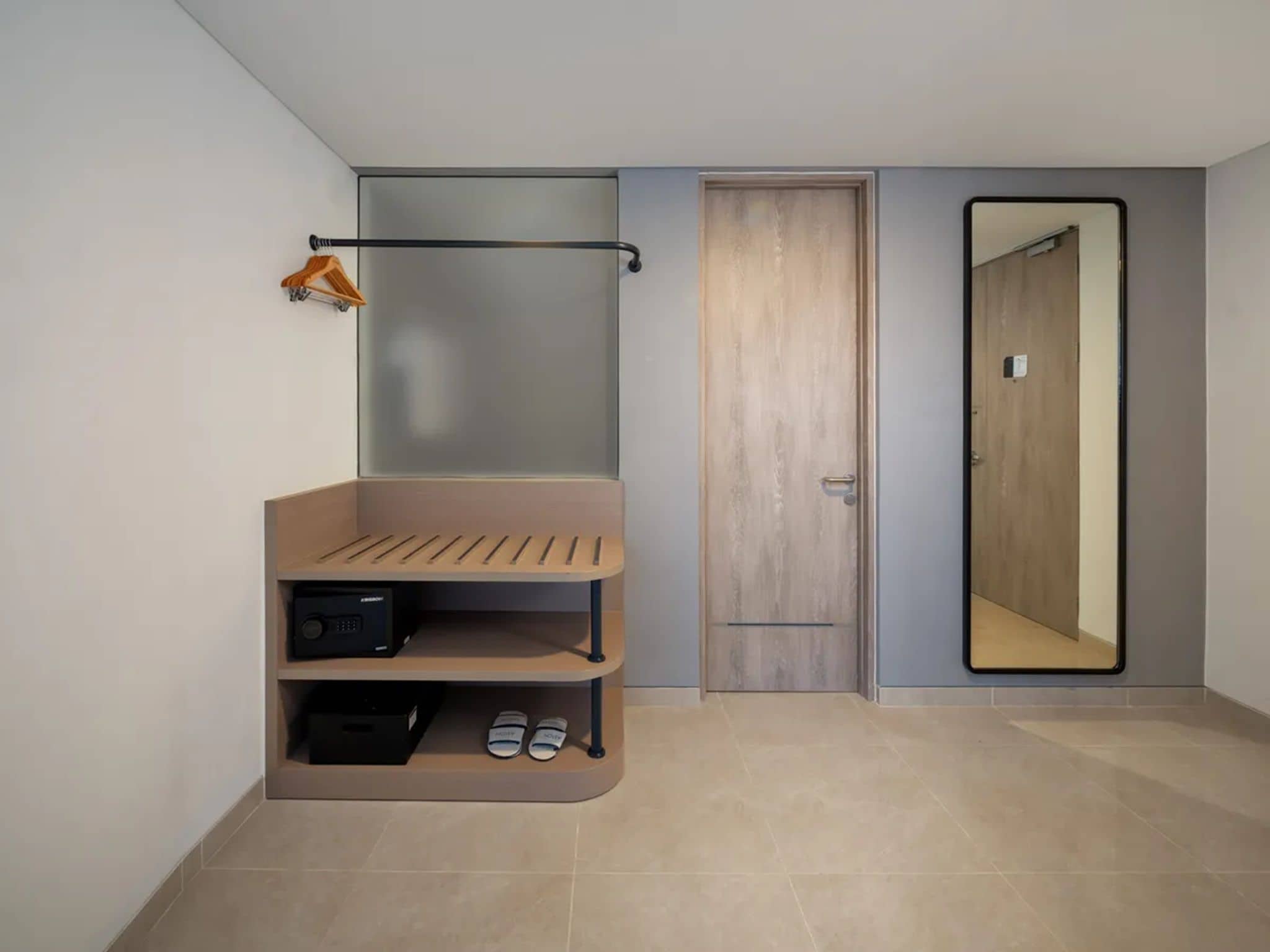 Un baño moderno con tocador de madera, un perchero y un espejo.