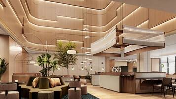 Um saguão moderno de hotel com área de estar central, escadaria e balcão de recepção.