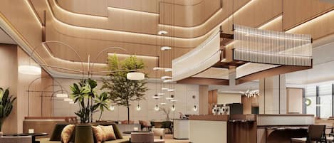 A modern hotel lobby with a central seating area, a staircase, and a reception desk.