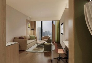 Ein modernes Wohnzimmer mit Sofa, Sessel, Couchtisch und Schreibtisch mit Stuhl.