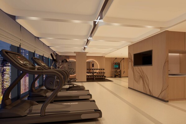 Une salle de sport moderne équipée de tapis de course, d’un téléviseur et offrant une vue sur la ville.