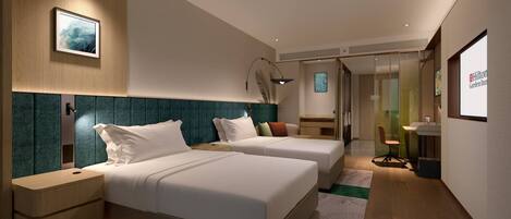 Une chambre d’hôtel moderne équipée de deux lits, d’un bureau et d’une salle de bain.