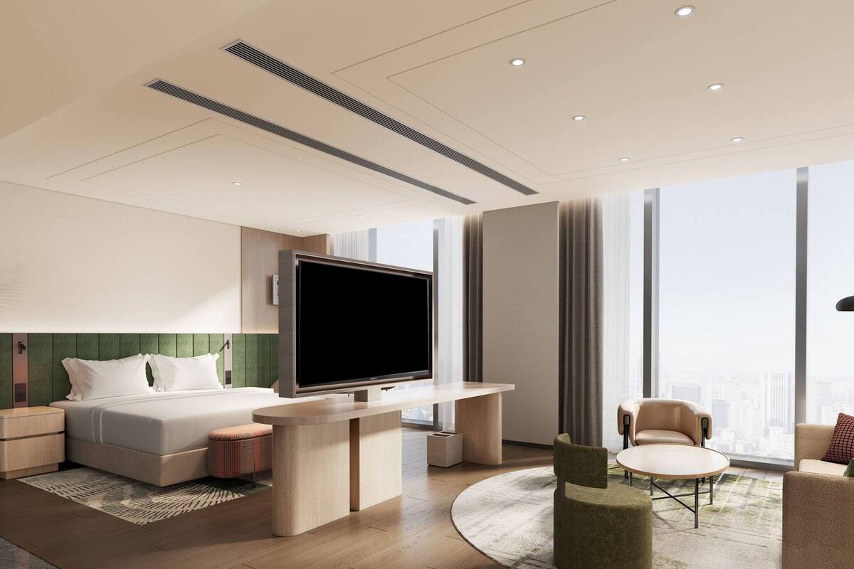 Une chambre d’hôtel moderne équipée d’un lit, d’une télévision, d’un bureau et offrant une vue sur la ville.