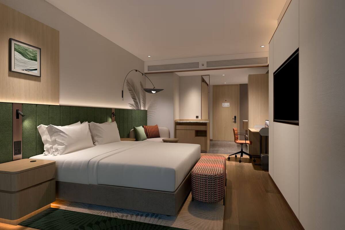 Une chambre d’hôtel moderne avec un grand lit, un bureau et une télévision.