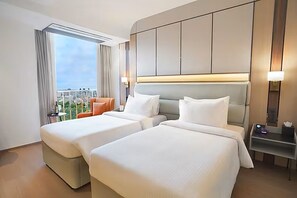 A hotel room with two beds, a view of the city, and a balcony with a chair. - The Orchid Chandigarh (Dera Bassi)