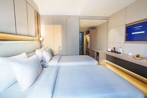 Une chambre d’hôtel moderne équipée d’un grand lit, d’une télévision et d’un mini-bar.