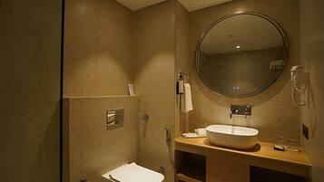 Un baño moderno con un espejo redondo grande, un lavabo blanco y una zona de ducha.