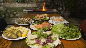 A wooden table with various dishes including seafood, salads, and vegetables. - Catba Backpackers Hostel & Pool Bar (Hai Phong)