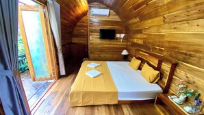A wooden cabin bedroom with a bed, a nightstand, and a window. - Catba Backpackers Hostel & Pool Bar (Hai Phong)