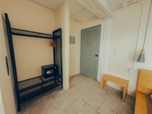 A room with a bunk bed, a small desk, a bench, and a door. - Viajero Panama (Panama City)