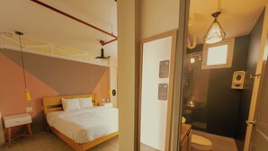 Een slaapkamer met een bed, nachtkastje en hanglamp.