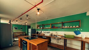 Een moderne keuken met een centraal eiland, houten aanrechtbladen en een groene achterwand.