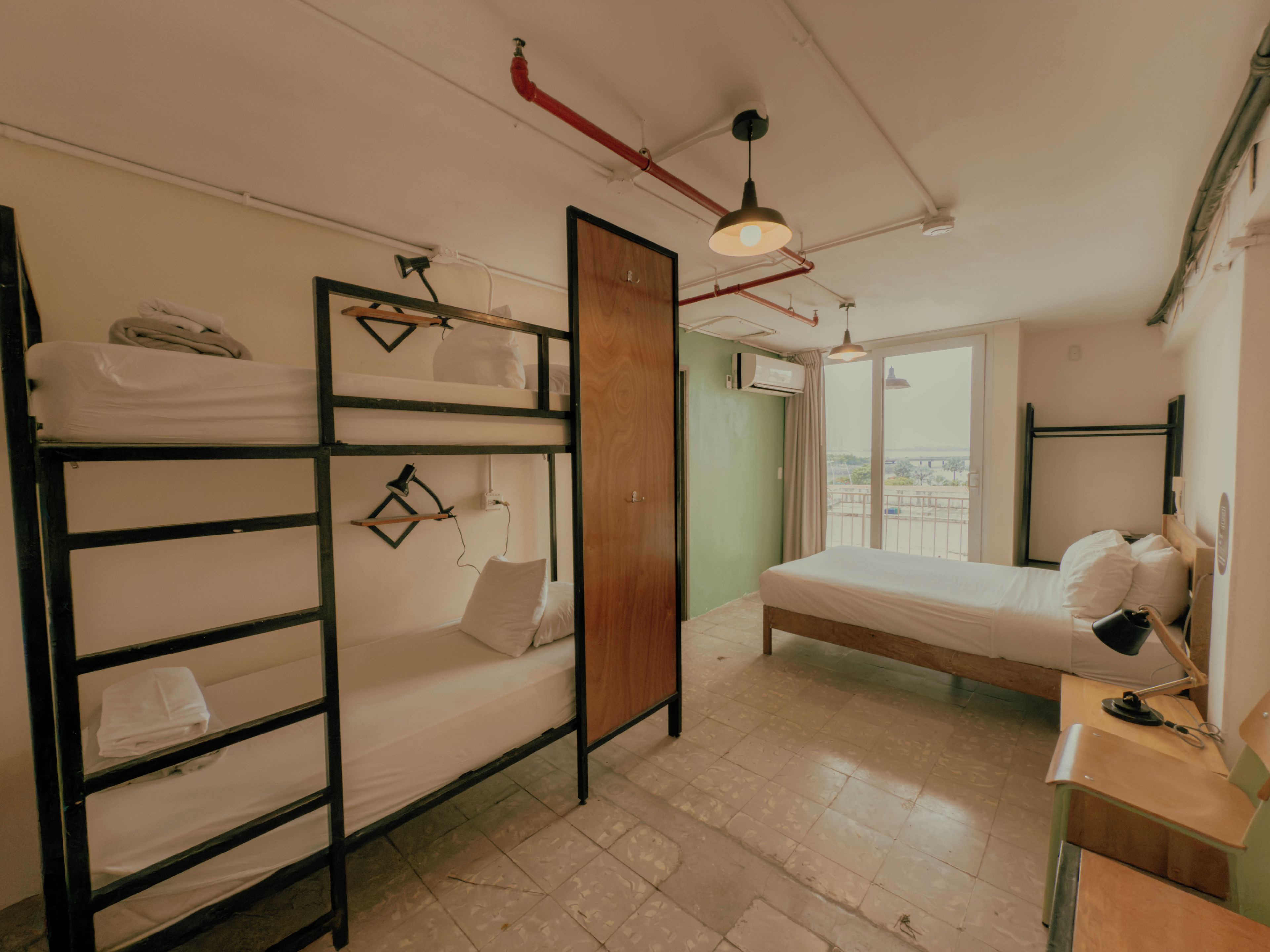 Un dormitorio con literas, un escritorio y una ventana con vistas.
