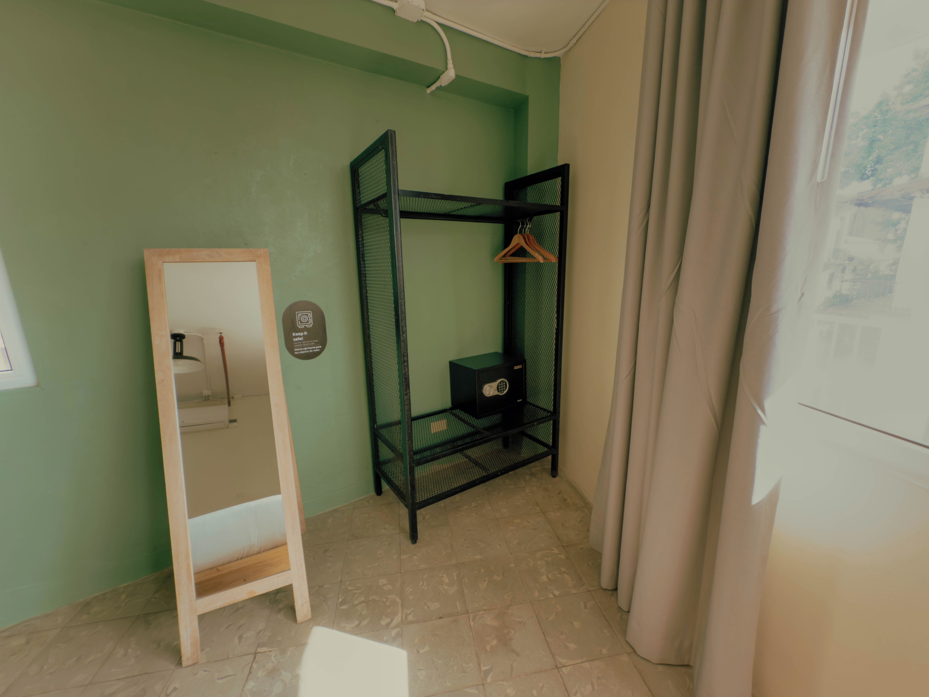 Una habitación con literas, una escalera de madera, un mueble pequeño y un estante en la pared con un perchero.