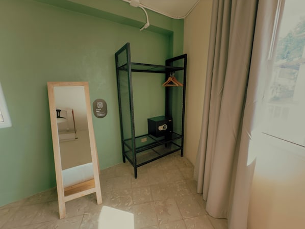 A room with a bunk bed, a wooden ladder, a small cabinet, and a wall-mounted shelf with a hanging rack. - Viajero Panama (Panama City)