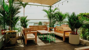 An outdoor patio with wooden furniture, potted plants, and a view of the cityscape. - Viajero Panama (Panama City)