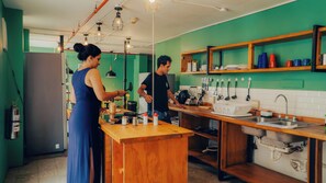 Una cocina moderna con paredes verdes, encimeras de madera y un fregadero de acero inoxidable.