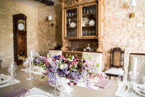 A dining table set with glassware and a floral centerpiece.