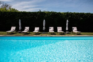 A swimming pool with six lounge chairs and umbrellas, surrounded by a hedge. - Les Manibelles (Amarens)