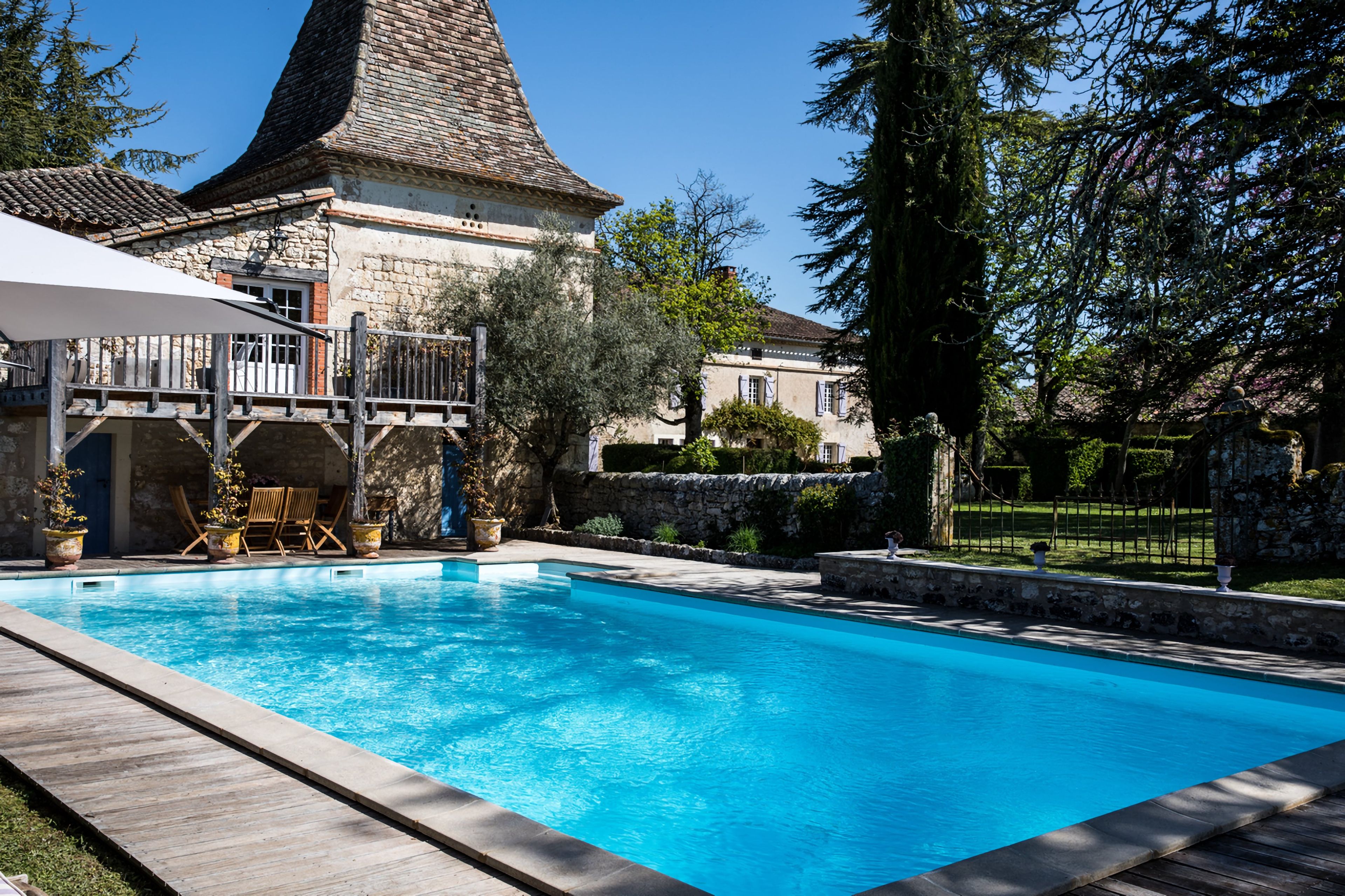 A swimming pool with a stone building in the background.