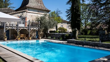 A swimming pool with a stone building in the background.