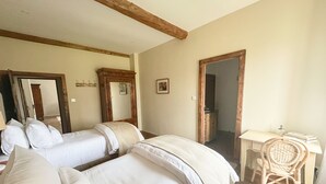 A room with two beds, a desk, a chair, and a mirror. - Les Manibelles (Amarens)