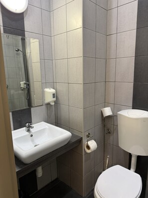 A bathroom with a white sink, a toilet, and a shower area. - Free Parking,free Breakfast, 15 Min To City Center (Budapest)