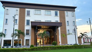 A modern hotel with a symmetrical facade, large windows, and a central entrance with a glass canopy. - Nirvana Grand Hotel And Resort (Gaya)