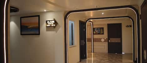 Corredor de hotel com placa indicando os números dos quartos de 2001 a 2014 no primeiro andar.