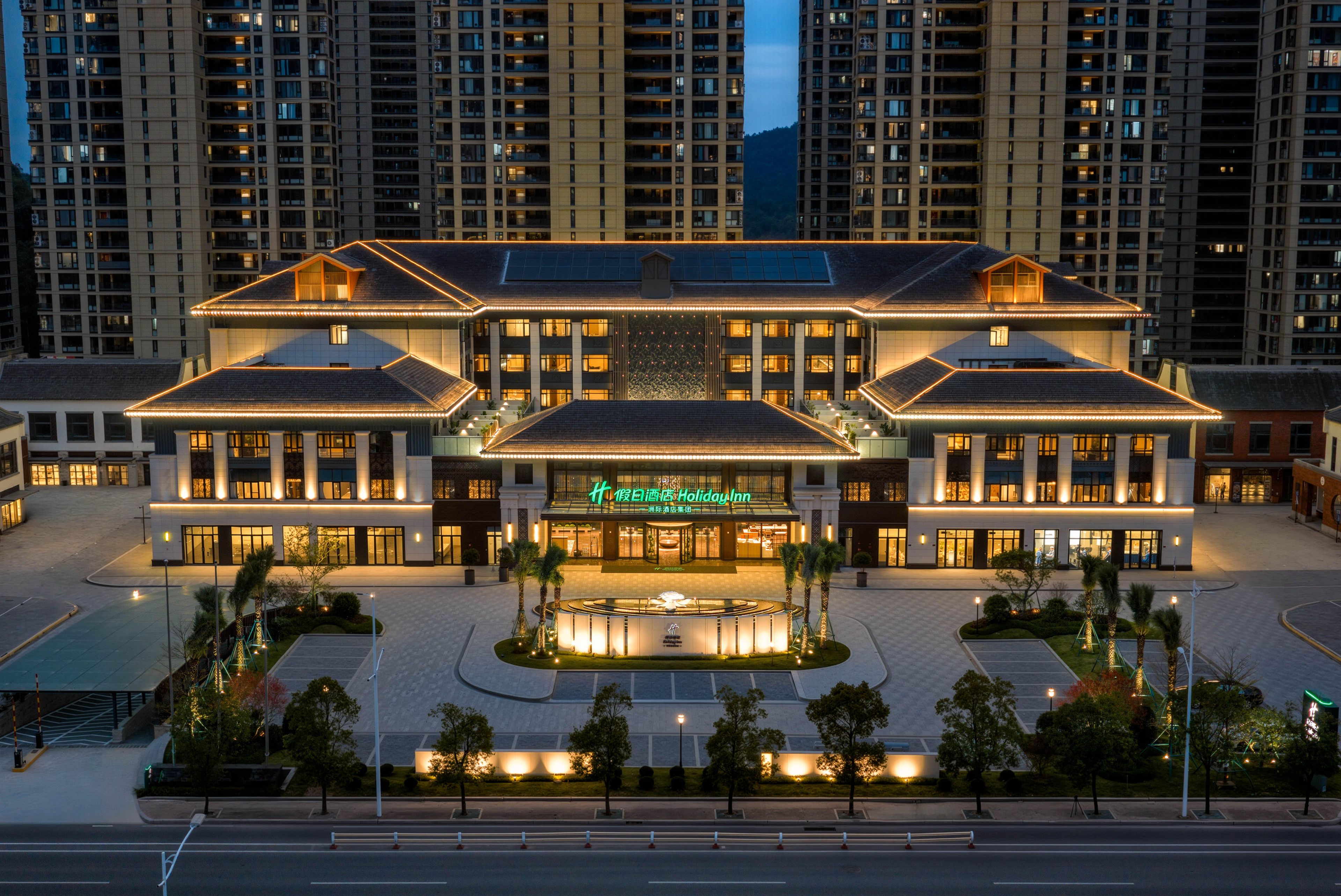 A multi-story hotel with a central courtyard, large windows, and a prominent entrance.