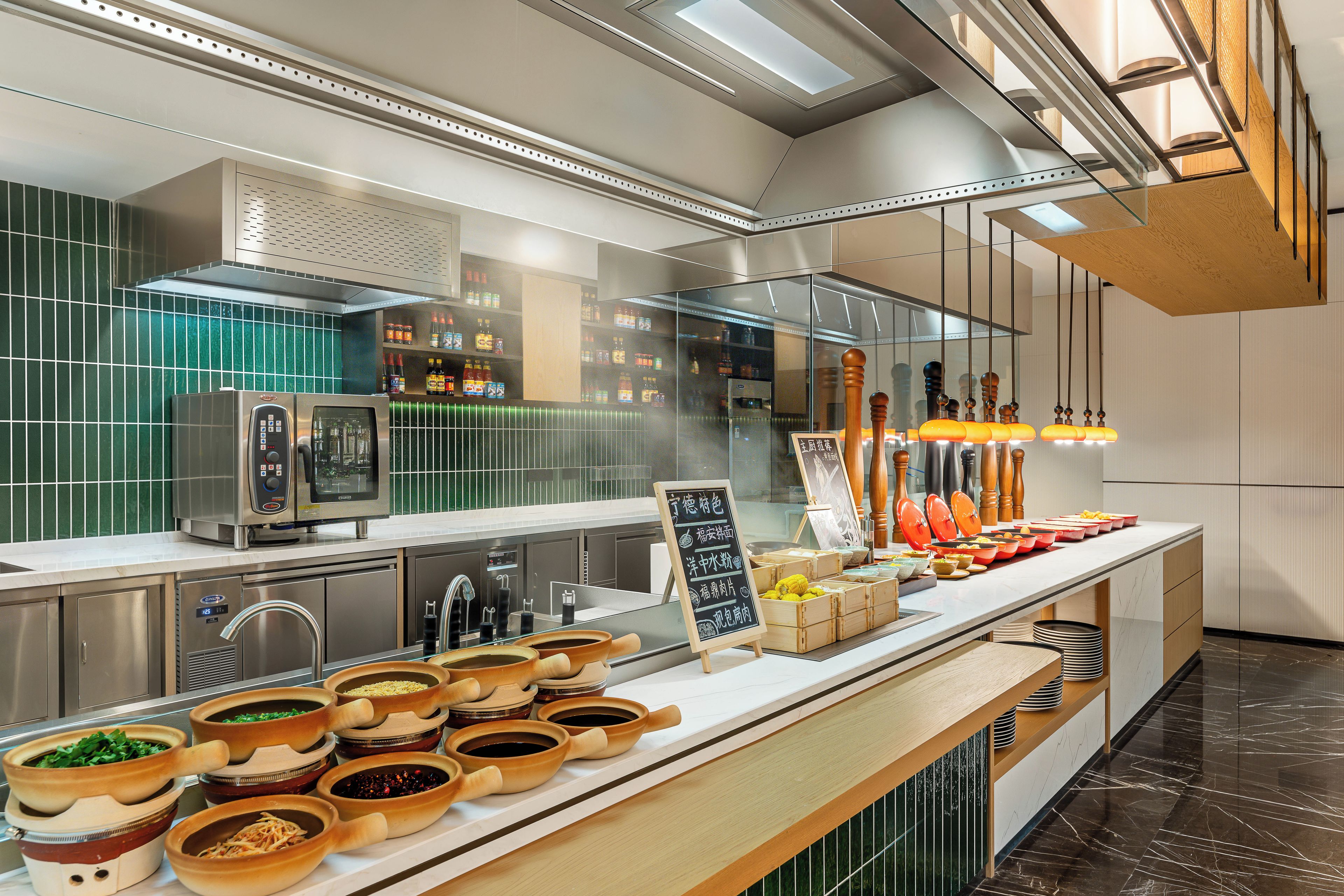 A modern kitchen with stainless steel appliances, a variety of cooking utensils, and a chalkboard menu.