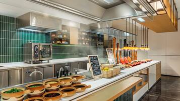 A modern kitchen with stainless steel appliances, a variety of cooking utensils, and a chalkboard menu.