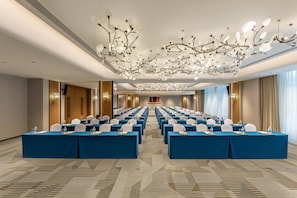 A conference room with rows of tables, chairs, and a modern chandelier. - Holiday Inn Ningde Jiaocheng (Ningde)