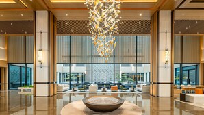 A modern lobby with a central water feature, seating areas, and large windows offering views of the outside. - Holiday Inn Ningde Jiaocheng (Ningde)