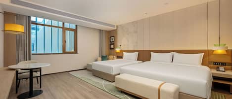 A hotel room with a large bed, two bedside tables, a small table, and a chair.