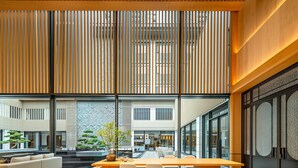 Eine moderne Lobby mit einer Rezeption, einer Sitzecke und großen Fenstern.