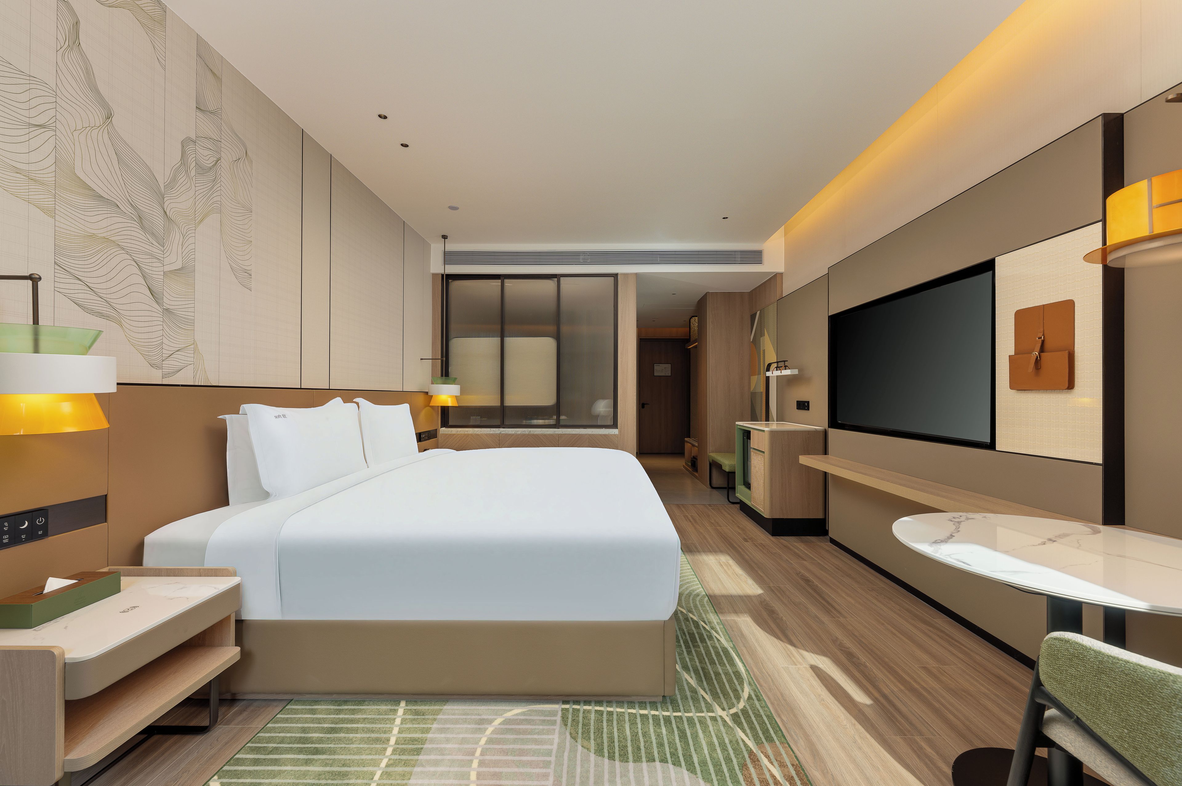 Una habitación de hotel moderna con una cama grande, mesitas de noche, un escritorio, una silla, un televisor y una pequeña mesa.