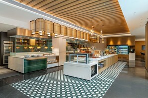 Una cuina moderna amb una illa central, il·luminació penjant i un terrapatí amb un disseny original.